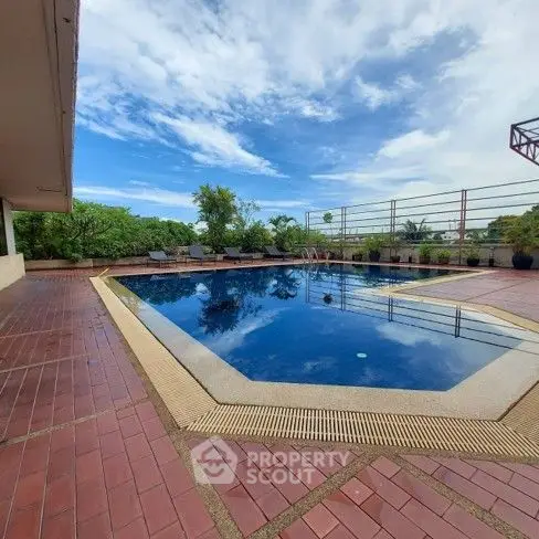 Luxurious rooftop pool with stunning sky view and lush greenery