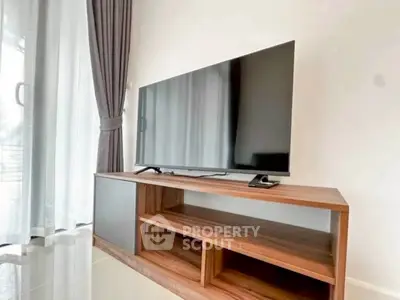 Modern living room with sleek TV stand and large flat-screen TV