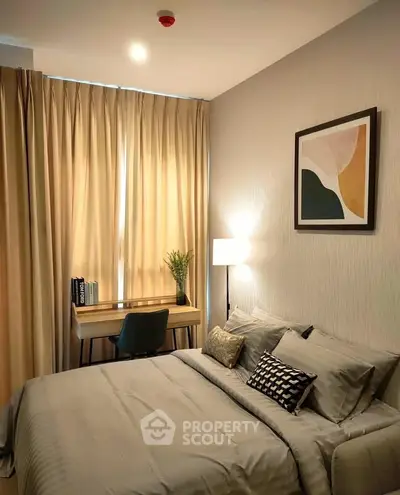Cozy bedroom with modern decor and natural light, featuring a stylish desk and comfortable bedding.