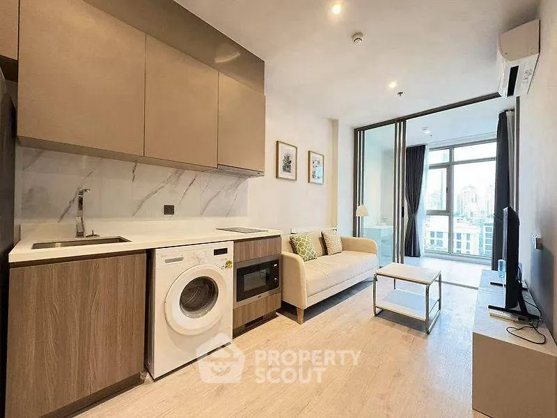 Modern open-plan living room with kitchen and city view