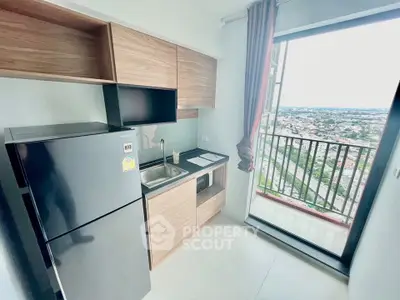 Modern kitchen with sleek cabinets and balcony view in high-rise apartment