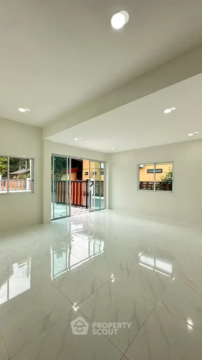 Spacious living room with glossy marble floors and large windows for natural light.