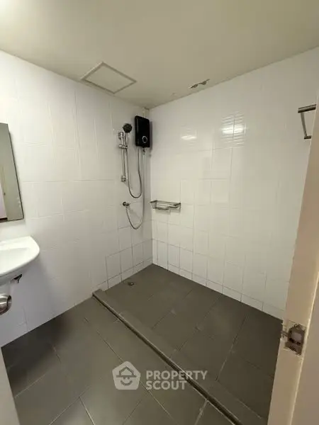 Minimalist bathroom with white tiles and shower area