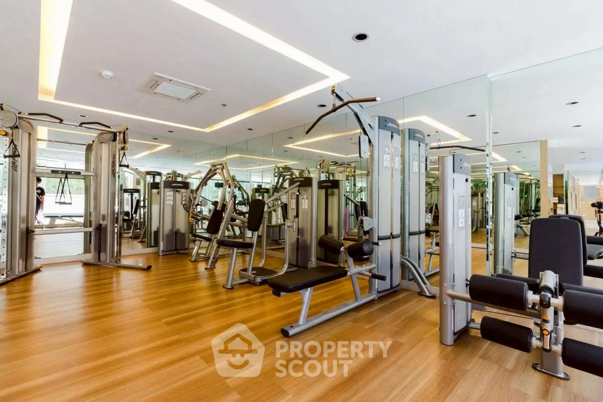 Spacious modern gym with state-of-the-art fitness equipment and mirrored walls.