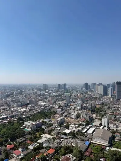 Stunning panoramic cityscape view from a high-rise building, showcasing urban skyline and clear blue sky.