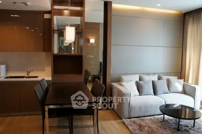 Modern living room with open kitchen, cozy sofa, and elegant dining area in a stylish apartment.
