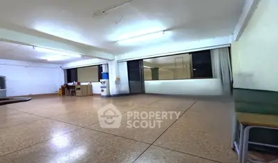 Spacious multipurpose room with large windows and tiled flooring