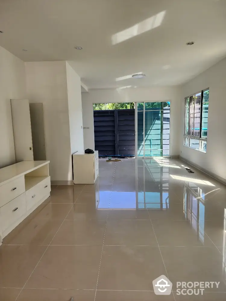 Spacious living room with glossy tiled floors and large windows for natural light