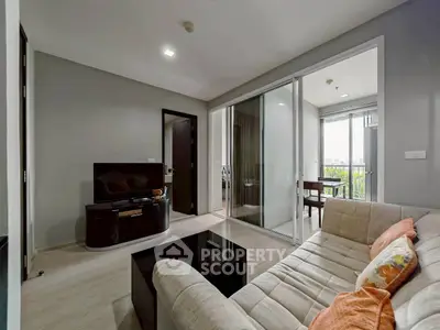 Modern living room with cozy sofa and sliding glass doors to balcony
