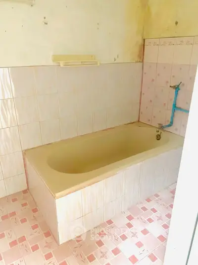 Vintage bathroom with classic bathtub and pink tile accents.