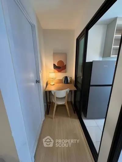 Cozy study nook with modern decor and adjacent kitchen area in compact apartment.