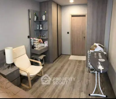 Modern bedroom with sleek design and ironing board, featuring wooden flooring and neutral tones.