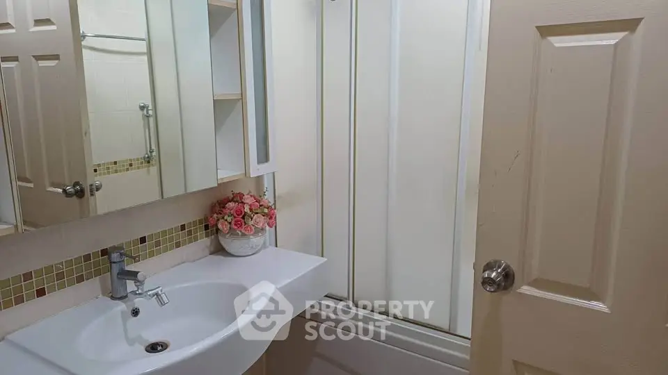 Charming bathroom with modern sink and floral decor, perfect for a cozy home ambiance.