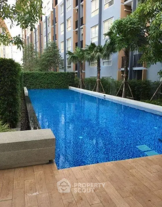 Luxurious condominium pool area with lush greenery and modern design.