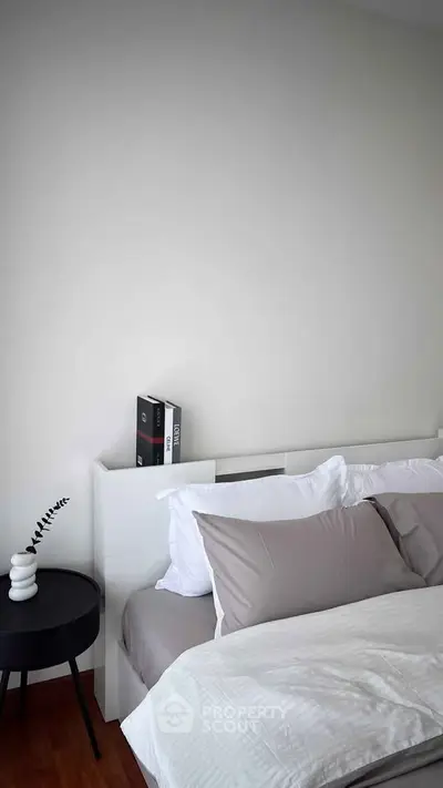 Modern bedroom with minimalist design and cozy bedding in a stylish apartment.