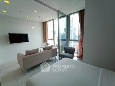 Modern living room with city view, featuring sleek furniture and large windows for natural light.