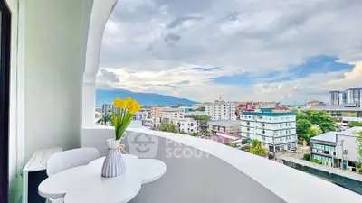 Charming balcony with stunning cityscape view and elegant outdoor seating.