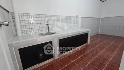 Spacious kitchen with tiled flooring and modern sink setup