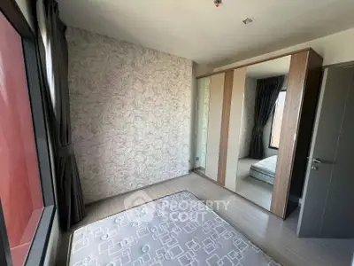 Modern bedroom with mirrored wardrobe and stylish wallpaper, perfect for urban living.