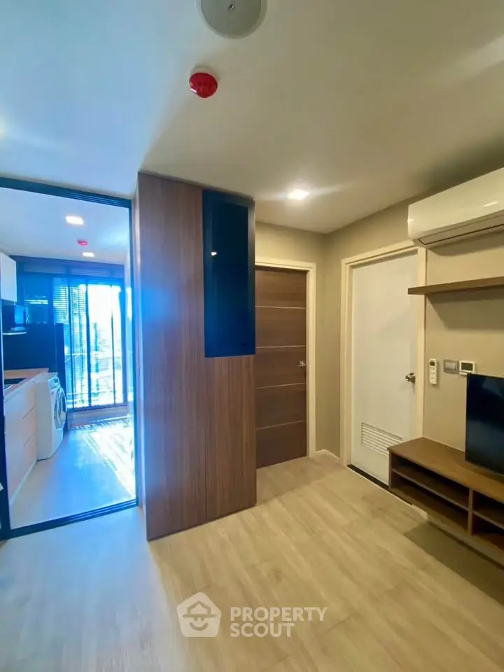 Modern apartment interior with open layout, featuring a sleek kitchen and cozy living area.