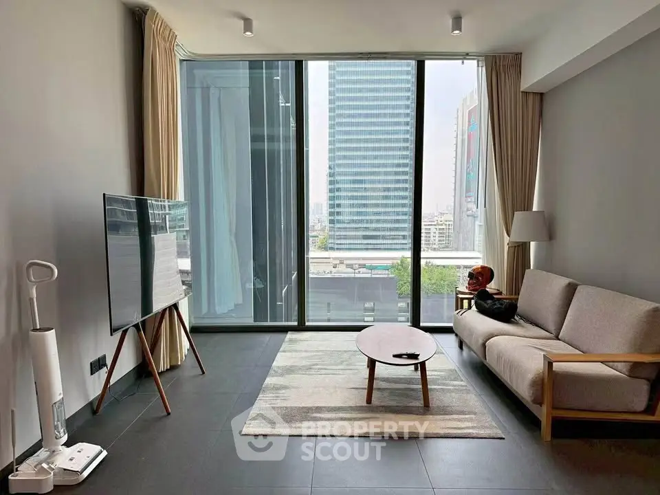 Modern living room with floor-to-ceiling windows and city view, featuring sleek furniture and minimalist decor.