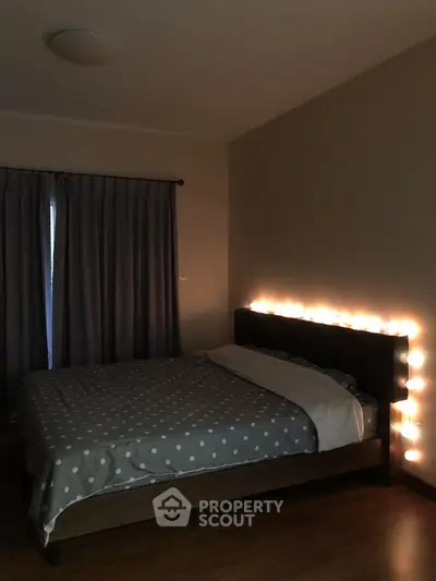 Cozy bedroom with ambient lighting and polka dot bedding