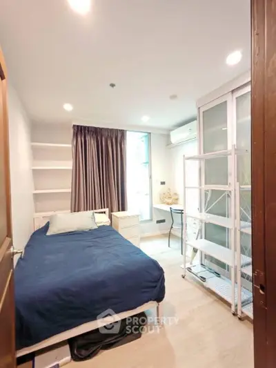 Cozy bedroom with modern furnishings and ample natural light, perfect for urban living.