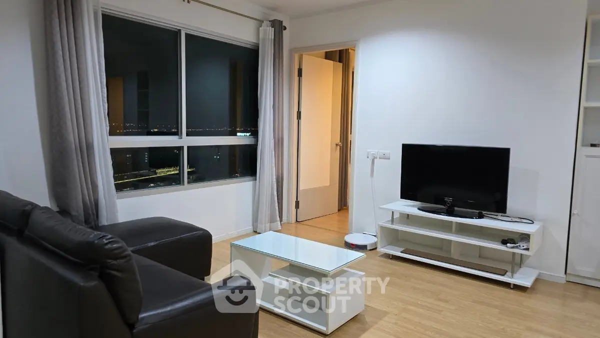 Modern living room with sleek furniture and city view at night