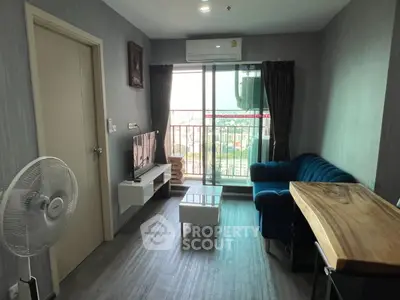 Modern living room with balcony view, stylish furniture, and natural light.