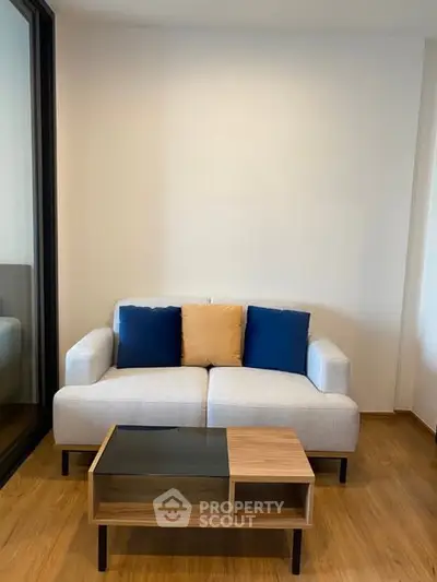 Modern living room with stylish sofa and coffee table on wooden flooring.