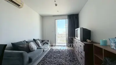 Modern living room with city view, cozy sofa, and stylish decor in a high-rise apartment.