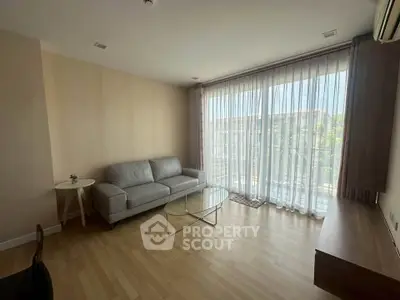 Spacious living room with large window and modern furniture
