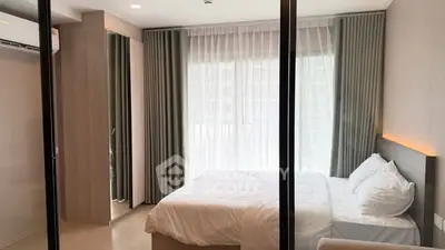 Modern bedroom with large window and stylish curtains in a contemporary apartment.