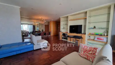 Spacious living room with elegant decor and dining area, featuring parquet flooring and modern furnishings.