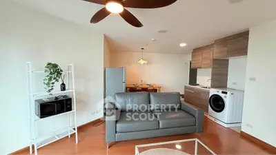 Modern living room with sleek furniture and integrated kitchen appliances in open layout.