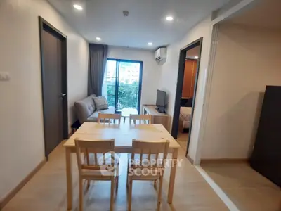 Modern apartment interior with cozy living room and dining area, featuring a balcony view.
