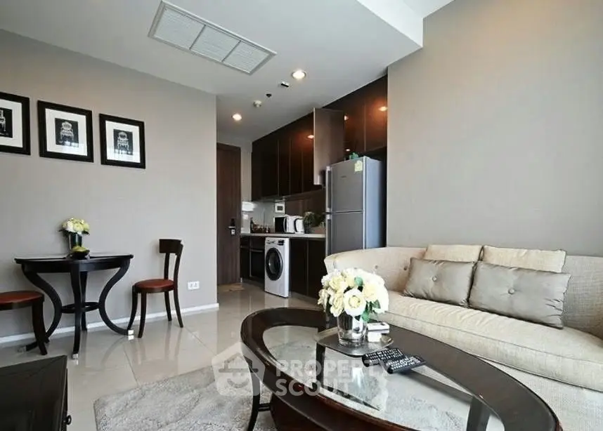 Modern living room with open kitchen, stylish decor, and cozy seating area in a contemporary apartment.