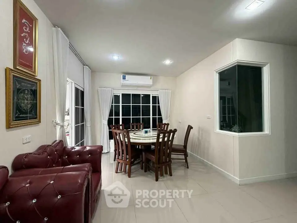 Elegant dining area with plush red seating and large windows in a modern home.