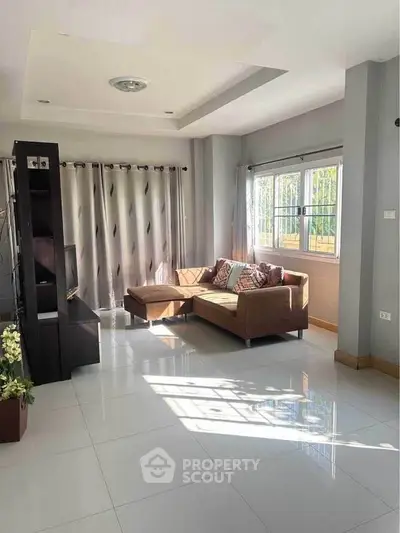 Bright and spacious living room with modern decor and large windows.