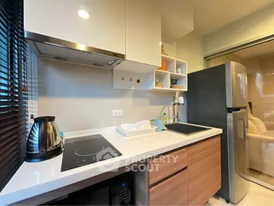 Modern kitchen with sleek appliances and stylish cabinetry in a cozy apartment.