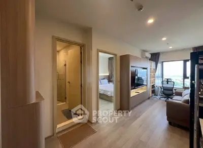 Modern apartment interior with open living room, bedroom, and bathroom view.