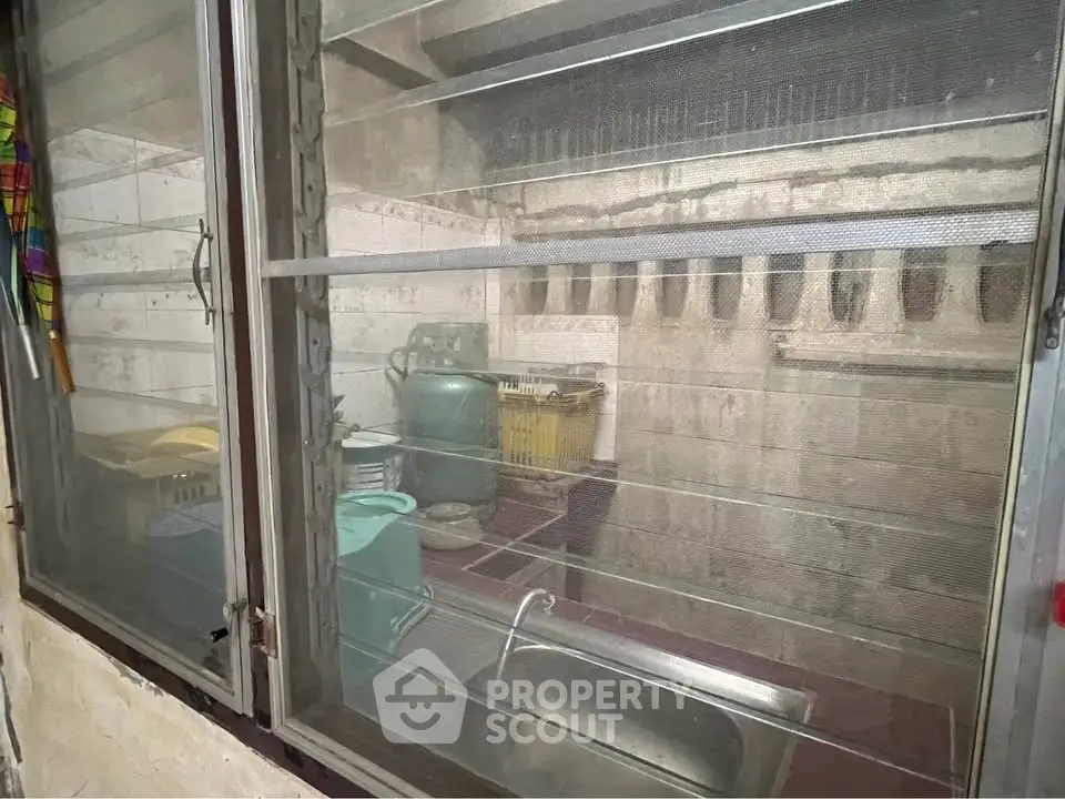Compact kitchen with window view, featuring essential appliances and storage space.