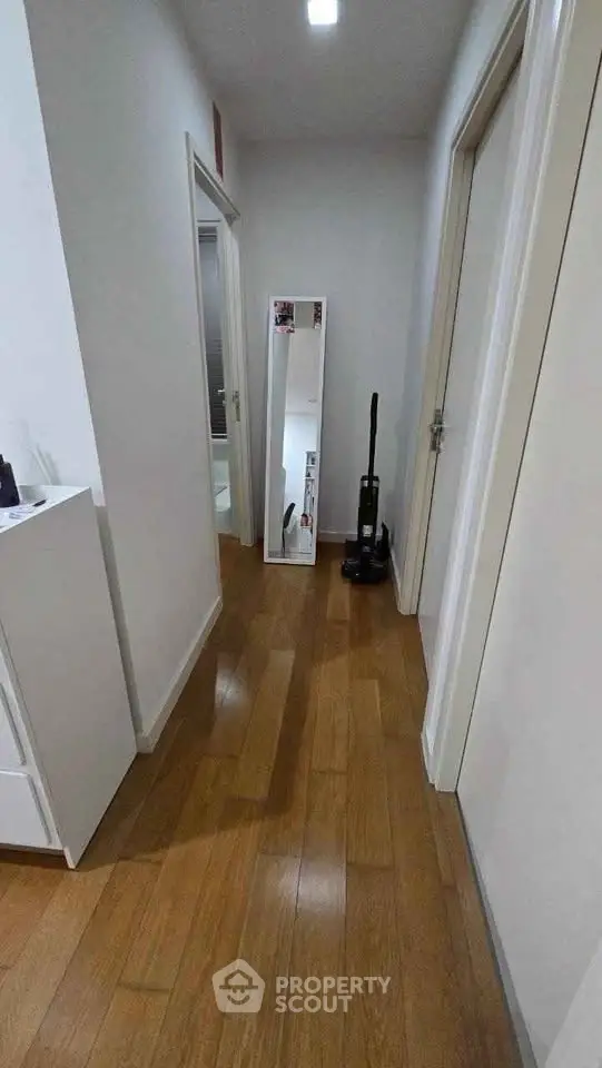 Modern hallway with wooden flooring and sleek decor in a contemporary home.