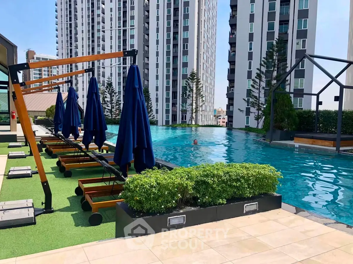 Luxurious rooftop pool with modern sun loungers and stunning cityscape views in a high-rise building.