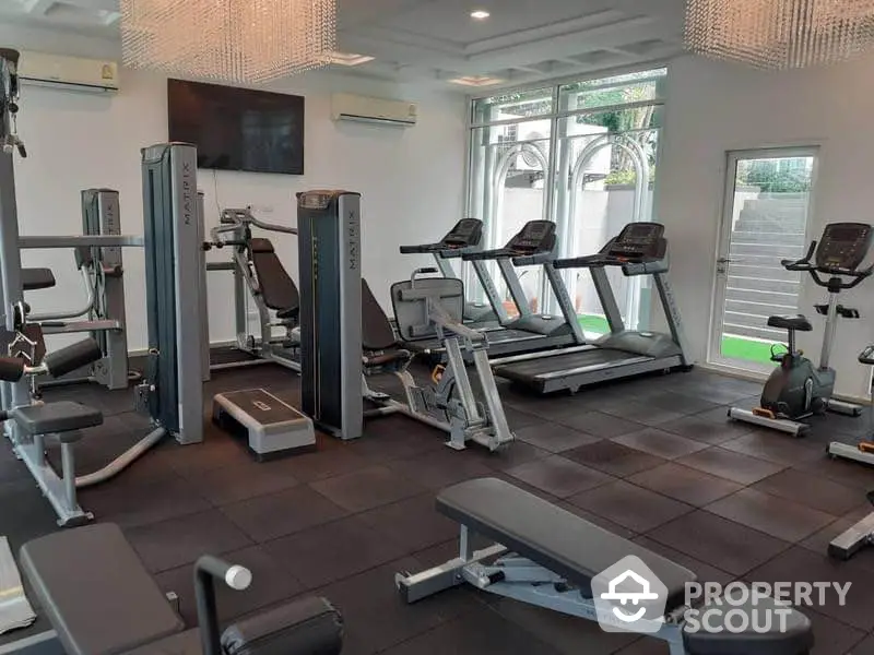 Modern gym with state-of-the-art fitness equipment and large windows for natural light.