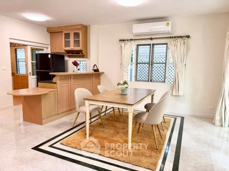 Charming dining area with elegant table and chairs, adjacent to a cozy kitchen, perfect for family gatherings.