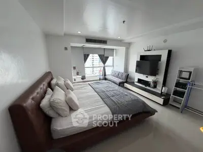 Modern bedroom with sleek design, featuring a large bed, wall-mounted TV, and city view window.