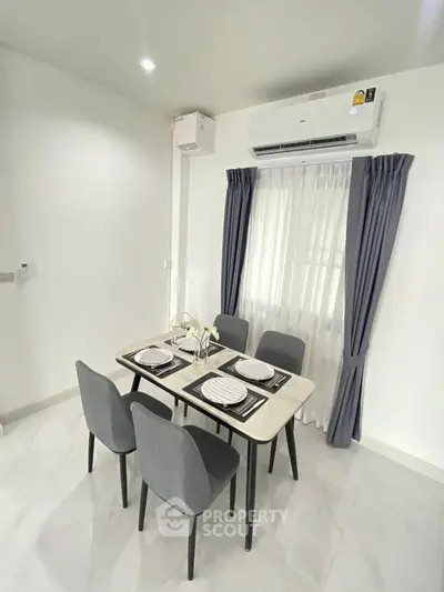 Modern dining area with elegant table setting and air conditioning, perfect for cozy meals.