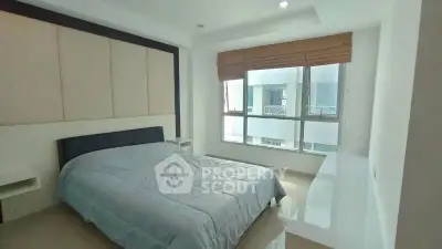 Modern bedroom with large window and stylish decor in a contemporary apartment.