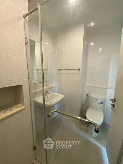 Modern bathroom with glass shower and sleek fixtures in a compact space.